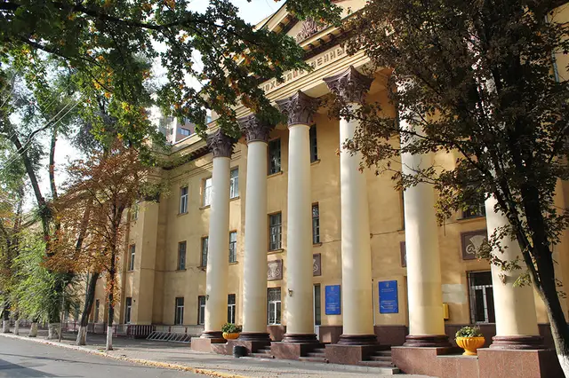 Зелений фасад старого корпусу ДДАЕУ з колонами й університетськими табличками