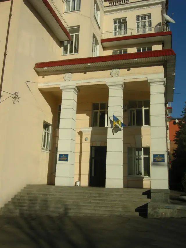 Вхід до корпусу ДДМУ з українським прапором і двома синіми університетськими табличками