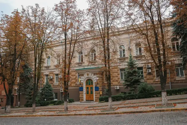 Осінній фасад будівлі окружного суду на проспекті Яворницького з центральним входом і табличками