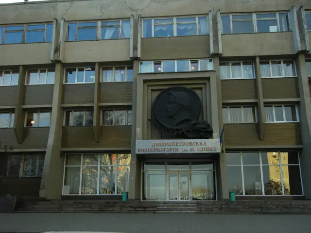 Головний вхід академії музики з бетонним модерністським фасадом, рельєфним медальйоном над дверима та вивіскою над порталом