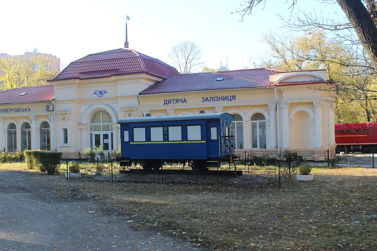 Станція Дніпровської дитячої залізниці та синій вагон у парку Глоби