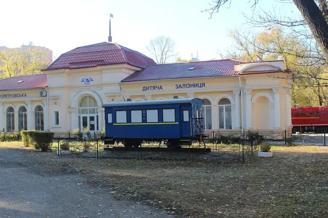 Станція Дніпровської дитячої залізниці та синій вагон у парку Глоби