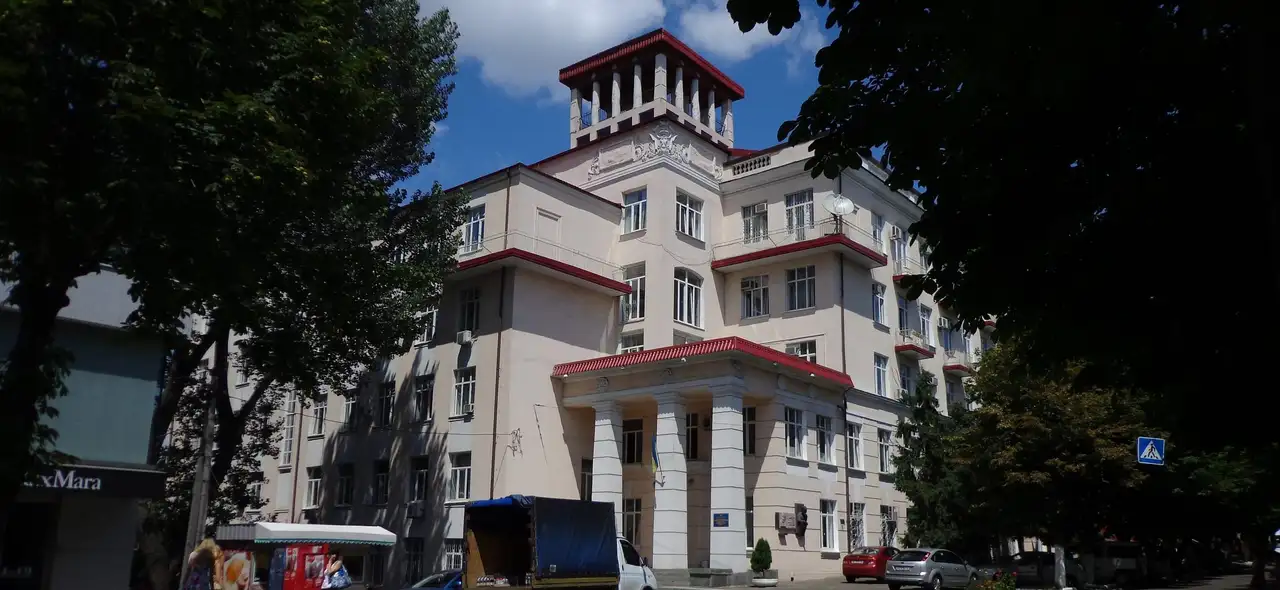 Світлий багатоповерховий корпус медичного університету з портиком головного входу, ротондою-бельведером на даху та меморіальними дошками