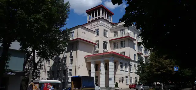 Світлий багатоповерховий корпус медичного університету з портиком головного входу, ротондою-бельведером на даху та меморіальними дошками