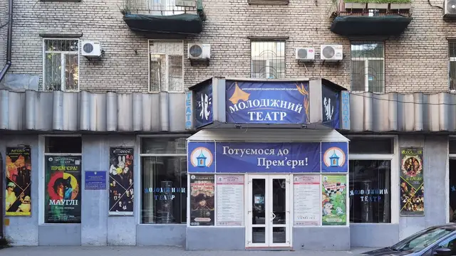 Літній фасад Молодіжного театру у Дніпрі з великим синім написом над центральним входом