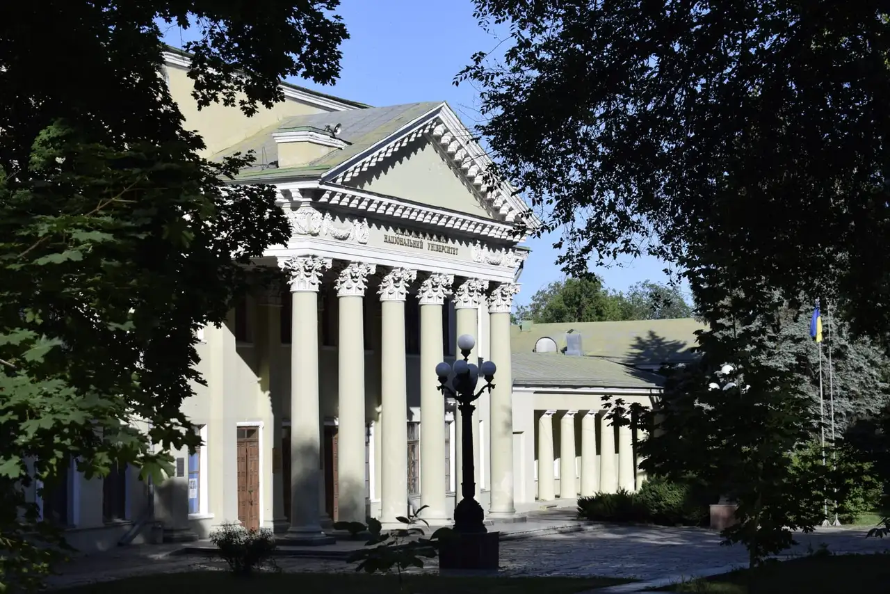 Колонадний фасад Палацу культури студентів ДНУ серед дерев парку Шевченка
