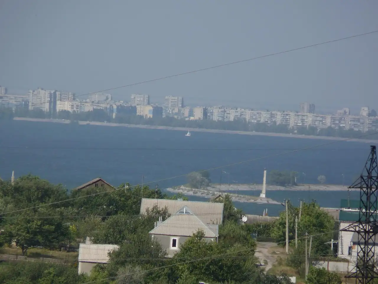 Вид через Дніпровське водосховище на лівобережну багатоповерхову забудову Кам’янського