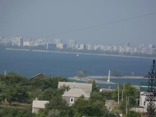 Вид через Дніпровське водосховище на лівобережну багатоповерхову забудову Кам’янського