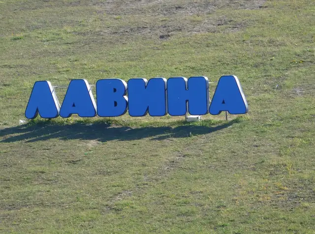 Великі сині літери «Лавина» на зеленому схилі парку розваг у Дніпрі