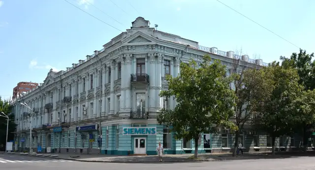 Довгий світло-блакитний фасад будинку Мізка на розі вулиць у Дніпрі