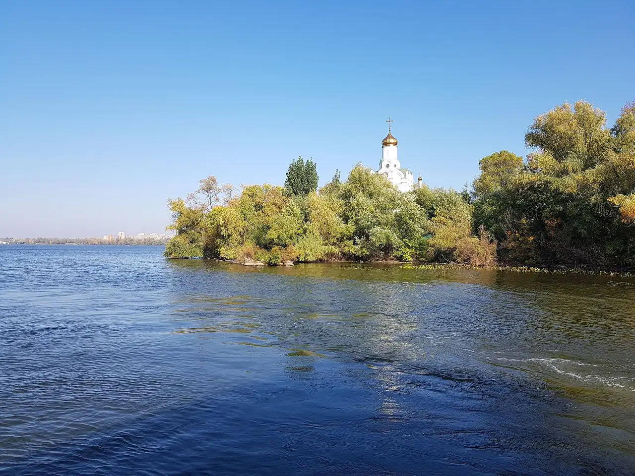 Свято-Миколаївський храм серед дерев Монастирського острова з боку Дніпра