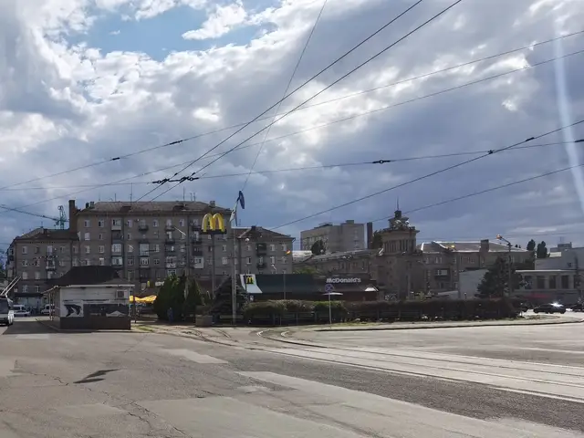 Літня Старомостова площа з трамвайними коліями, контактною мережею та забудовою транспортного вузла