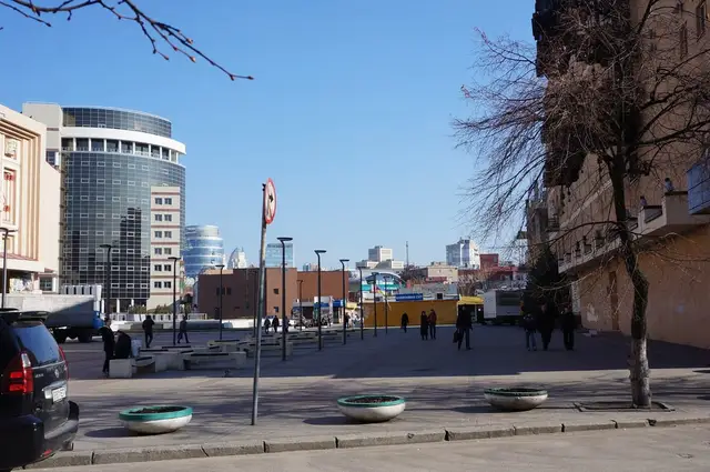 Пішохідна смуга Театрального бульвару в Дніпрі з бетонними вазонами, лавами, ліхтарями та різночасовою забудовою обабіч