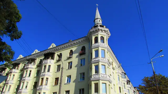 Сонячний верхній фасад будинку на Яворницького, 26 за адресою Culturist, із зеленими деревами
